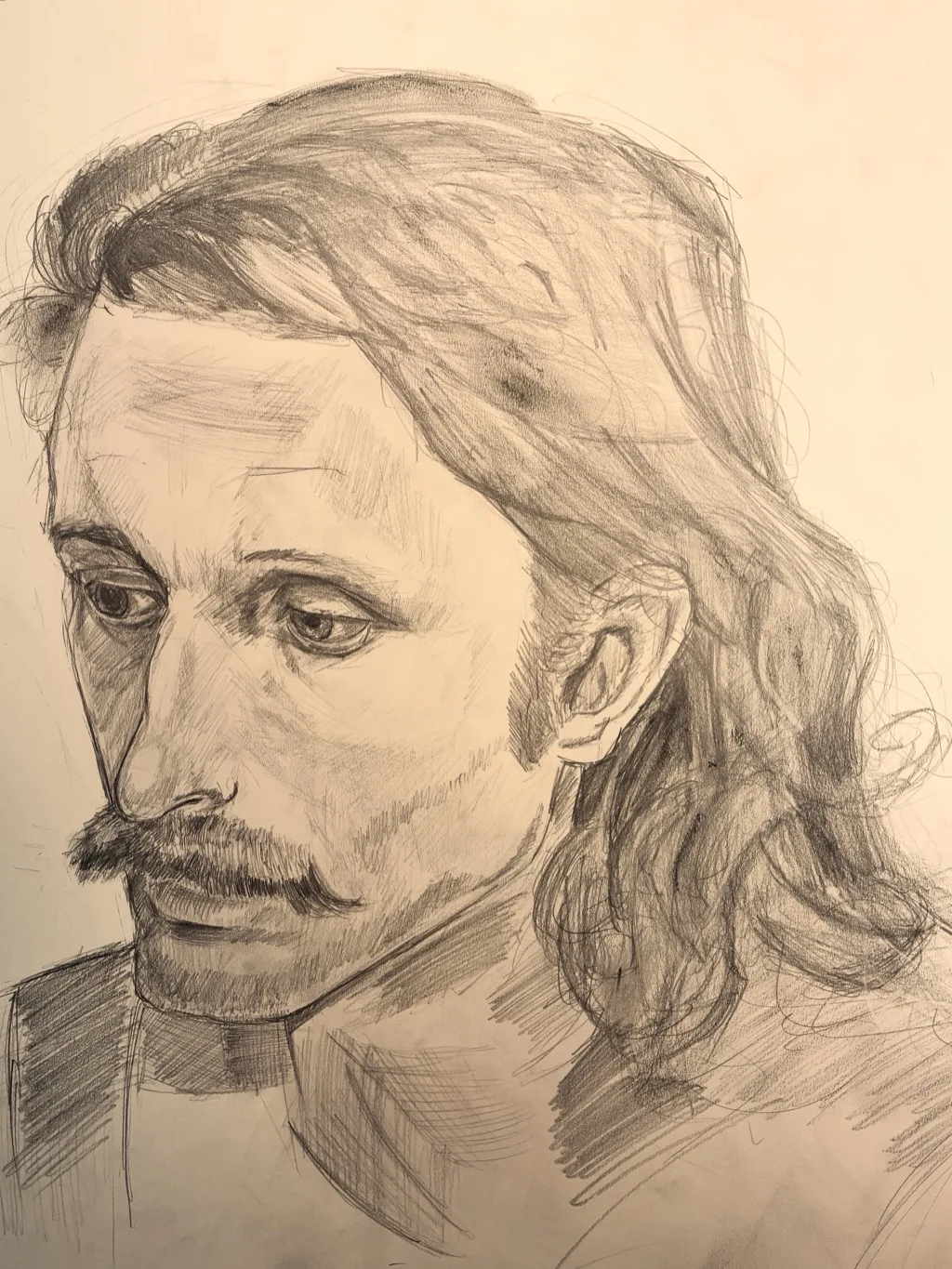Graphite portrait of a long-haired man with a mustache looking down