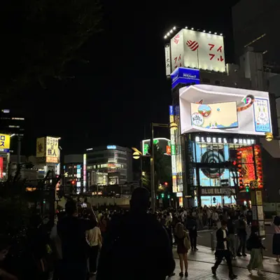 Crowded Tokyo street at night with lit billboards