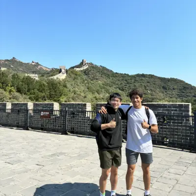 Two friends giving thumbs up on the Great Wall of China