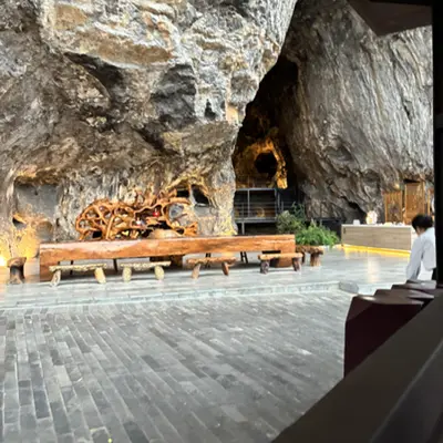Cave restaurant with a carved wooden table under a rock overhang