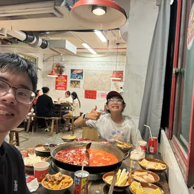 Friends sharing a spicy hot pot meal at a restaurant