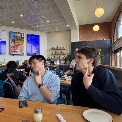 Two friends posing jokingly at a cafe table