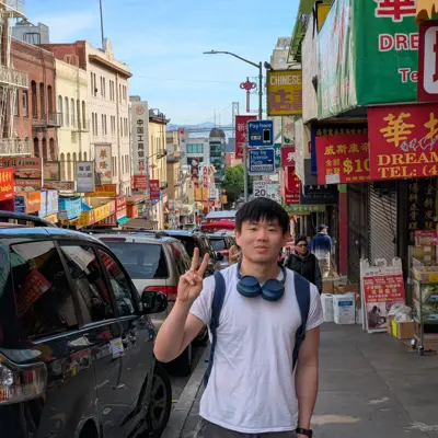 Joseph flashing a peace sign on a street in San Francisco Chinatown