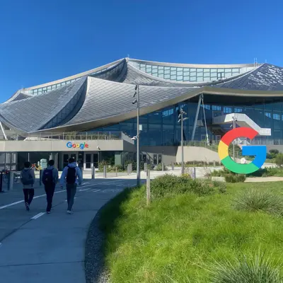 Visitors walking toward a Google campus building with a G sign