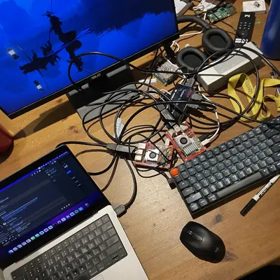Desk with a laptop, monitor, and Raspberry Pi wiring