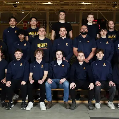 Queen's wrestling team group photo in navy team gear